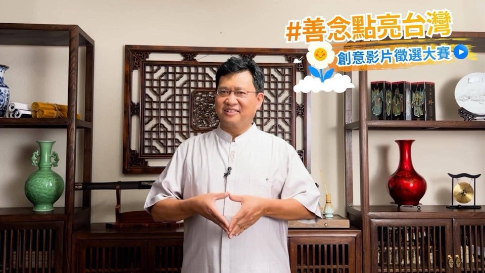 善念大使江峰在中式書房中雙手比出愛心