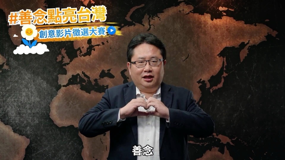 善念大使矢板明夫在世界地圖前比出愛心手勢