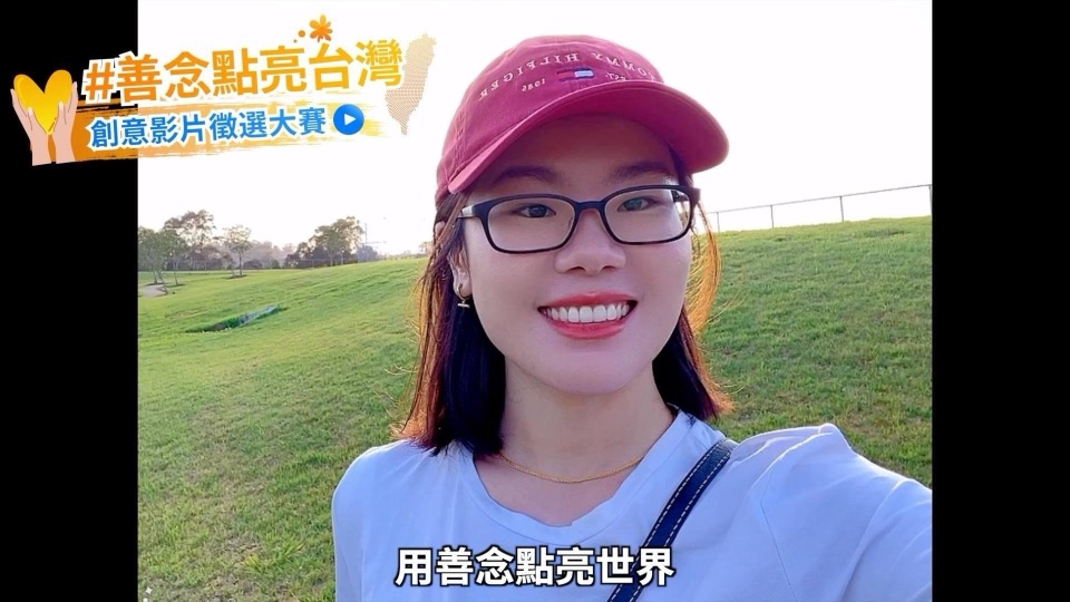 善念大使真飛戴紅色帽子在草地上微笑